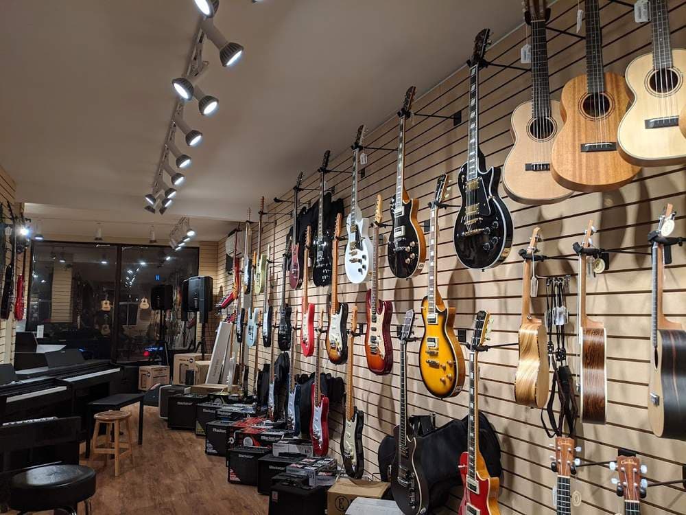 Guitar wall at École de musique du Marché — electric and acoustic guitars on display